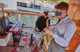 Three jazz band members playing jazz on the deck of the Yacht Manhattan for a Evening Jazz Cruise