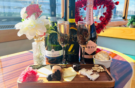 Champagne and cheese displayed on a table aboard a classic yacht