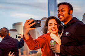 A couple taking a selfie on a sightseeing cruise in NY Harbor with Classic Harbor Line