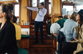 A tour guide giving a tour on a boat in NYC Harbor