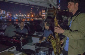 Jazz Band playing on the decks of a large sailboat with NYC in the background