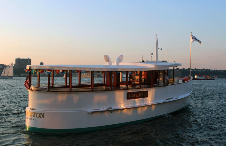 Stern shot of the yacht Kingston with no passengers aboard it at sunset in the Hudson River. New York Family: Kid's Birthday Parties aboard a boat!