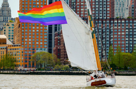 a pride flag waving from a sail boat