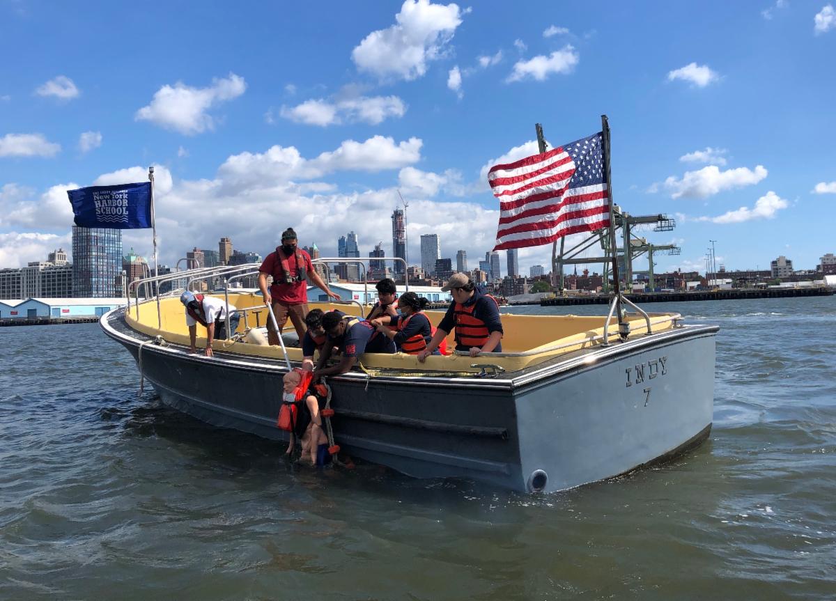 Children Rescuing a dummy for Safety Drills in NY Harbor aboard a boat