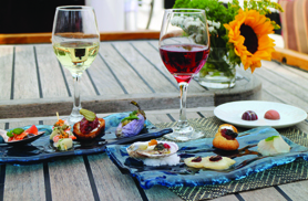 several assortment of dishes of seafood and fruit, with half filled wine glasses