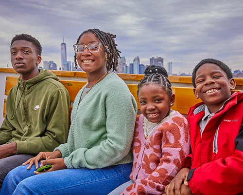 For kids on a boat with the NYC skyline behind them.
