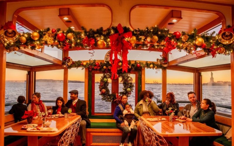 Small gathering sitting in the back of Yacht Manhattan II decorated in Holiday Decor for a Cocoa and Carols Cruise