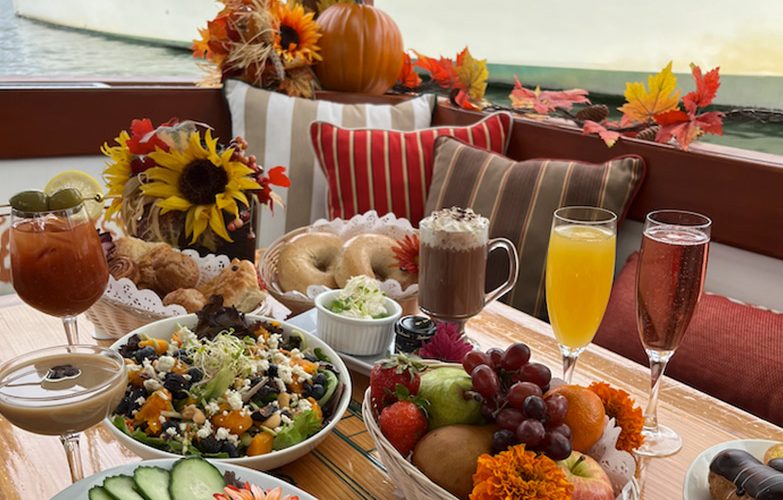 Close up photo of fruits, veggies, and drinks on a fall decorated table