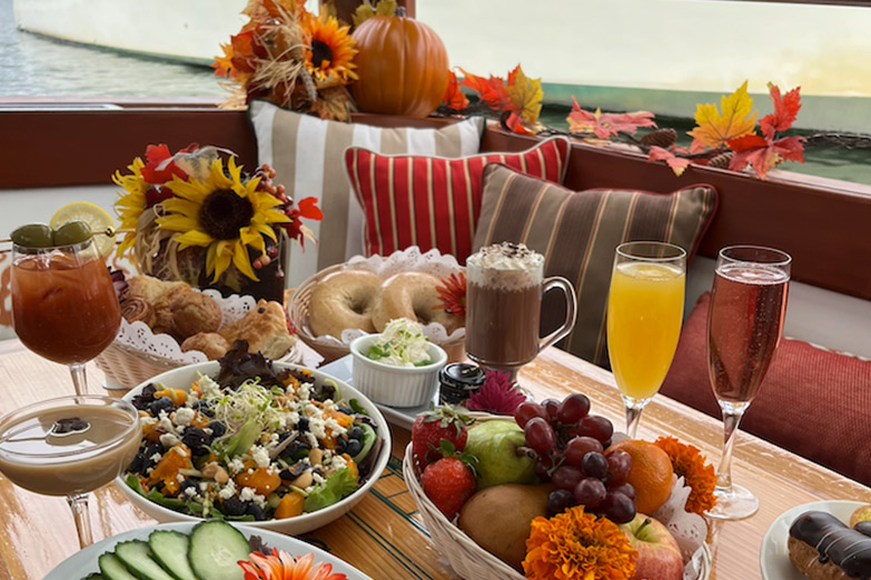 Close up photo of fruits, veggies, and drinks on a fall decorated table