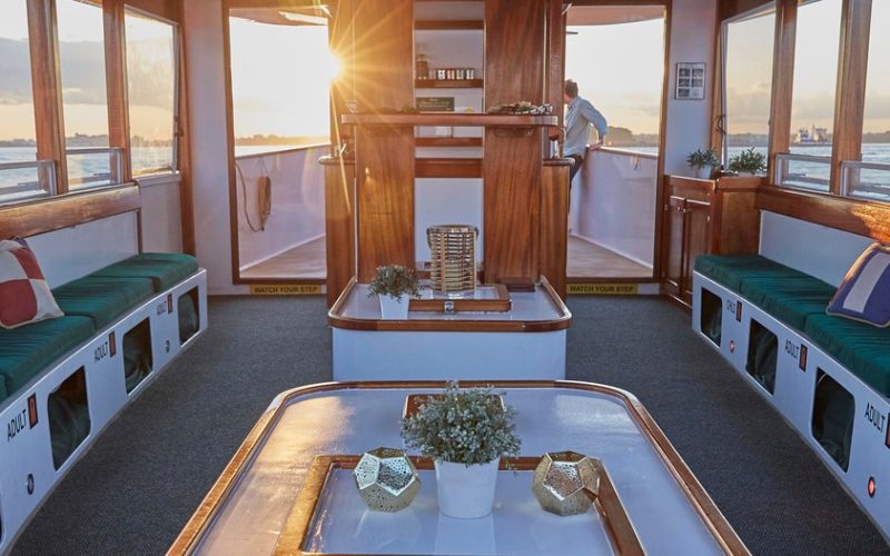 The interior salon of Yacht Kingston looking towards the Captain house with the Sunset seen through the doors that are open to the forward deck