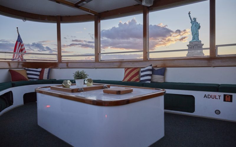 Viewing the Statue of Liberty from the main salon of yacht Kingston at sunset