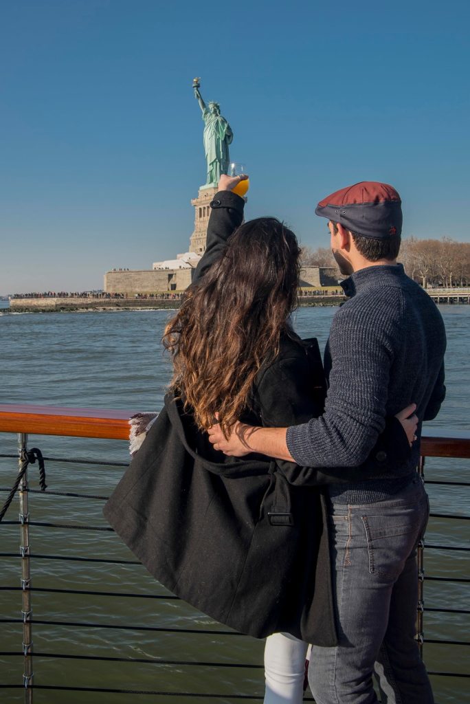 Couple raises a glass to Lady liberty on motor yacht Manhattan II