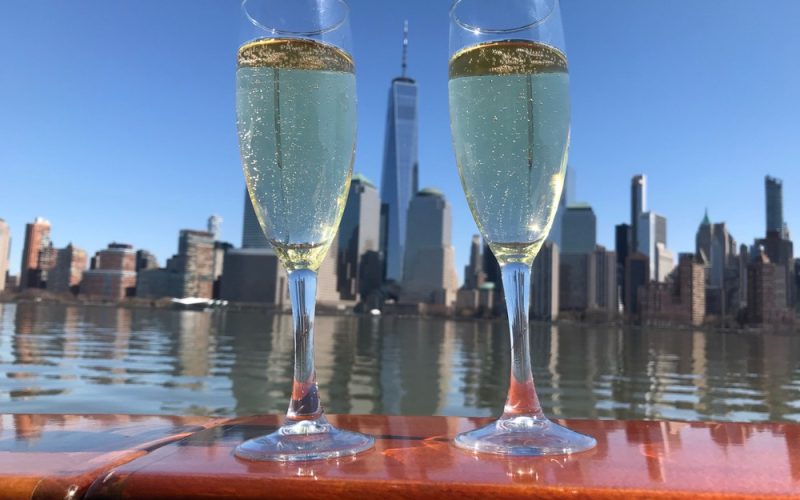 Two glasses of Valentine's Day Champagne flank either side of One World Trade on the deck of Manhattan II