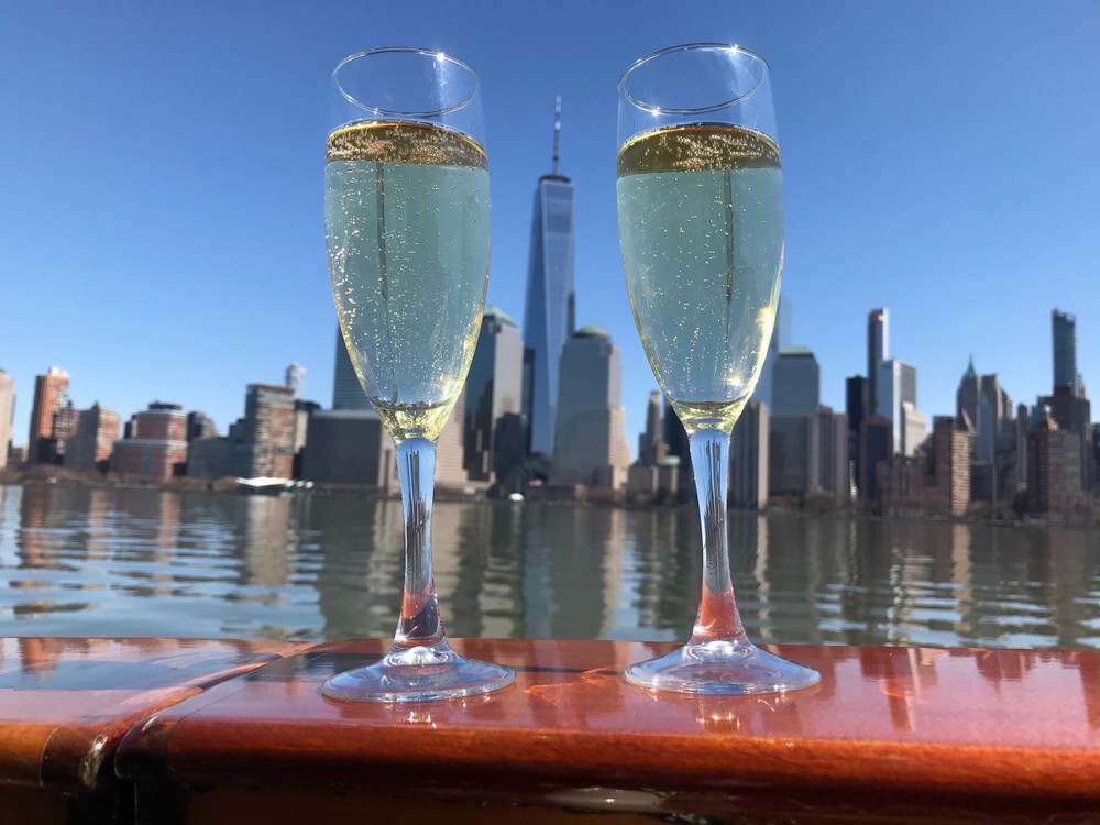 Two glasses of Valentine's Day Champagne flank either side of One World Trade on the deck of Manhattan II