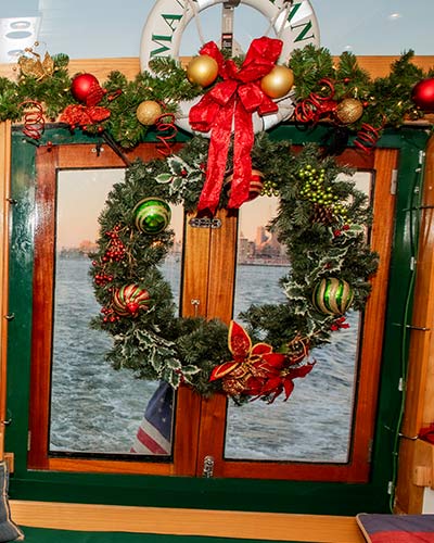 Up close photo of a wreath on the Yacht Manhattan II for the NYC Holiday Cruise