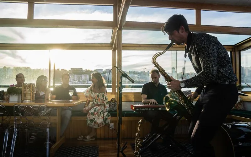 A jazz band playing with guests sitting at a table on a classic yacht