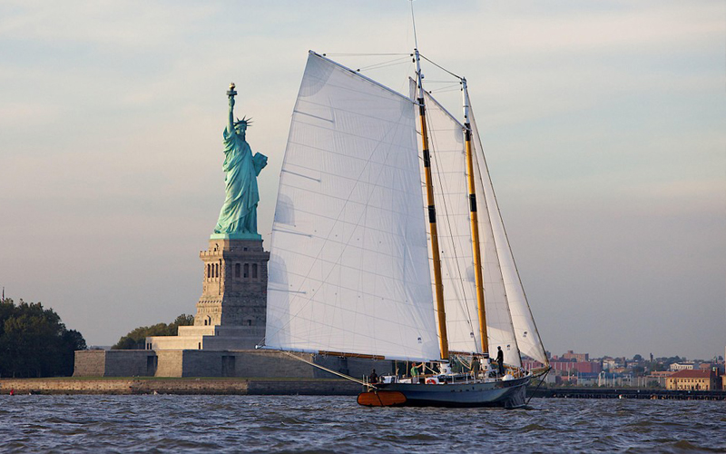 Schooner America 2.0 sailing in front of the Statue of Liberty in NY Harbor