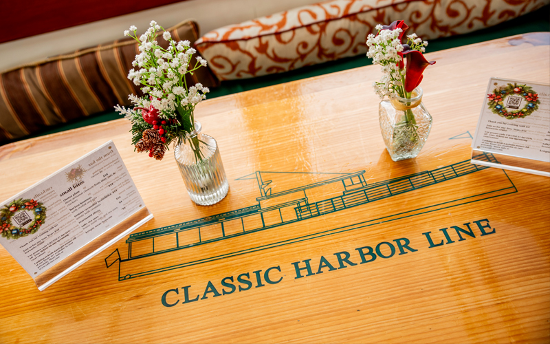 Teak and Mahogany Table with a classic yacht etched in with the name Classic Harbor Line