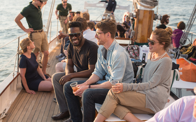 Guests enjoying drinks on the deck of Schooner Adirondack while sailing in NY Harbor.