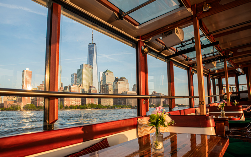 Main salon of yacht Manhattan with the NYC Skyline outside the windows