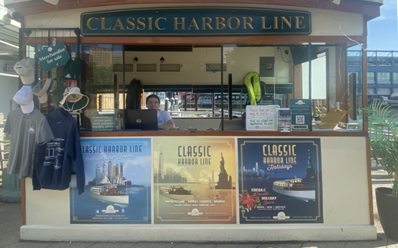 A ticket booth with a representative sitting in it at Chelsea Piers for Classic Harbor Line