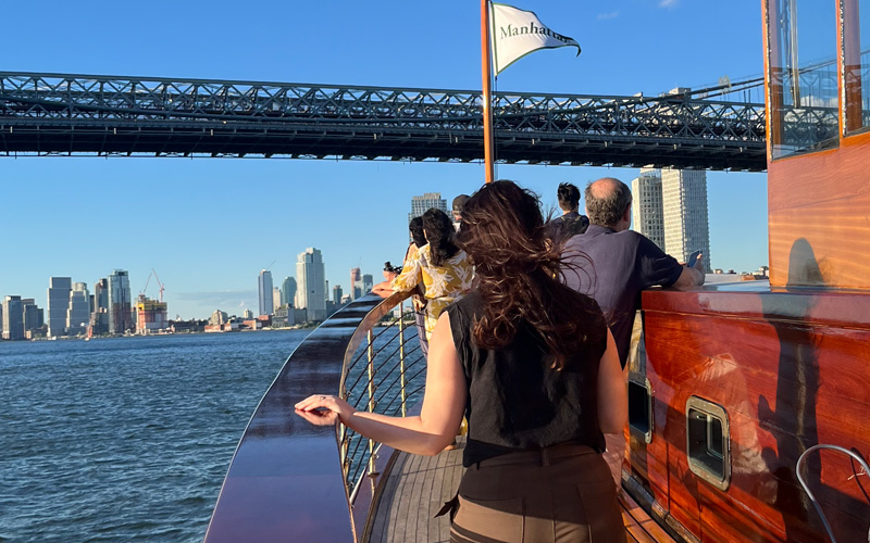 Guests on the bow of a yacht going under the Manhattan Bridge in NYC