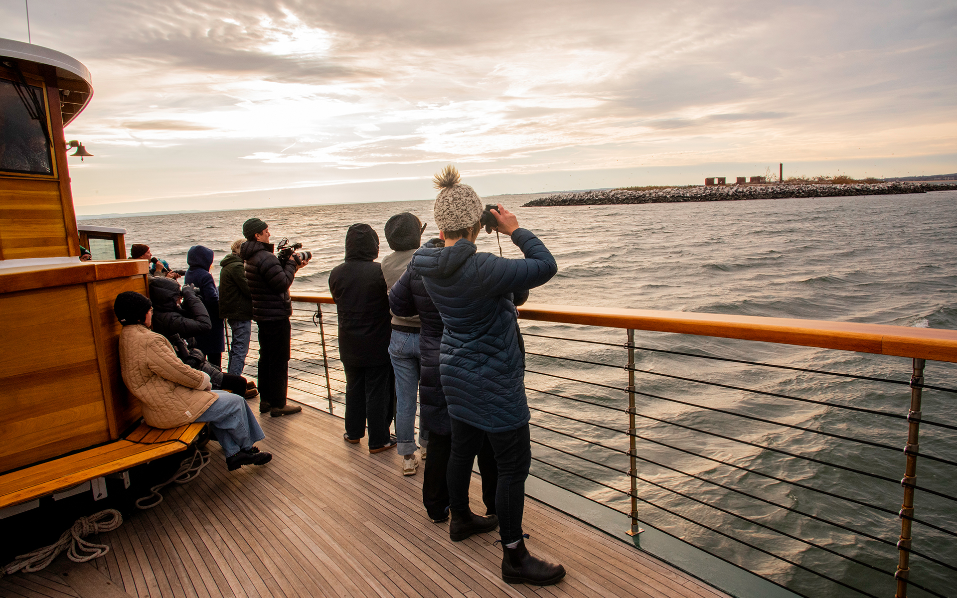 Guests on the bow of Yacht Manhattan looking off at Hoffman Island