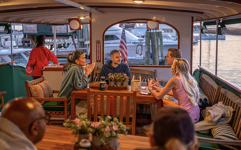 Couples sitting in the back salon of yacht Full Moon at sunset.