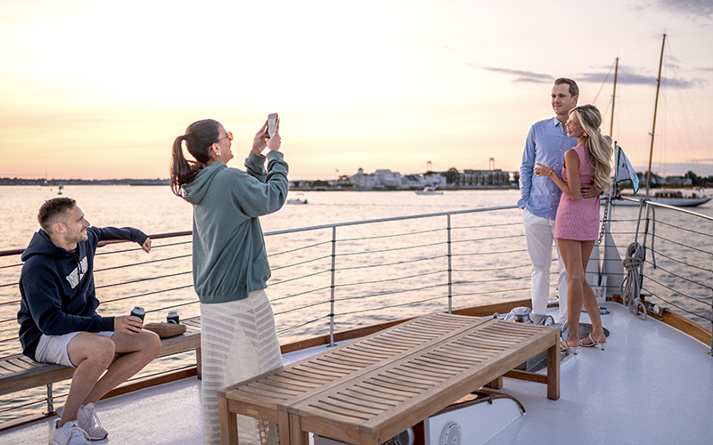 Couple getting their photo taken on the bow of yacht Full Moon at Sunset.