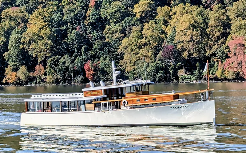 Yacht Manhattan Cruising up the Hudson River with the Grand Palisades in the background.