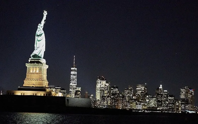 CityLightsSerenade1 Statue of Liberty lit up at night