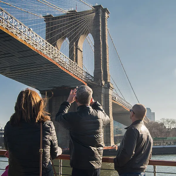 WinterSightseeingBlurp2 Three guests looking at the Brooklyn Bridge from the bow of yacht Manhattan