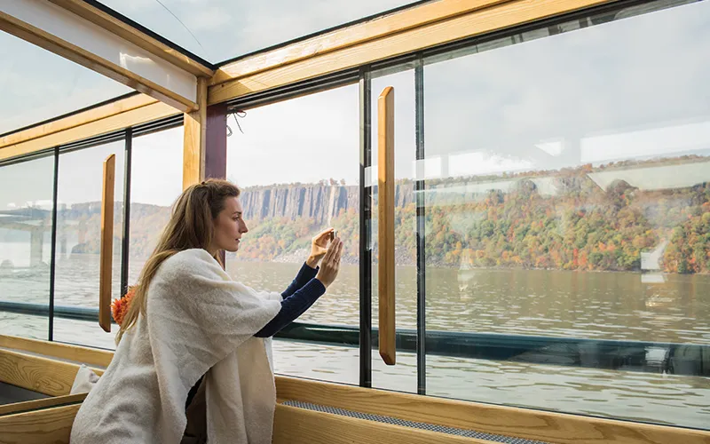 FallFoliage8 Woman taking a photo of the grand palisades on a fall foliage cruise with classic harbor line