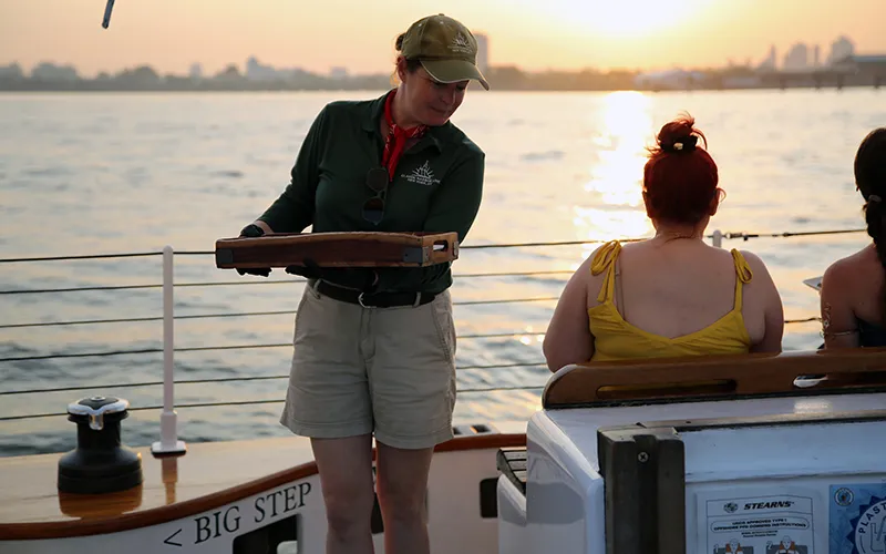 Tapas3 Crew member serving food with the sun setting behind them