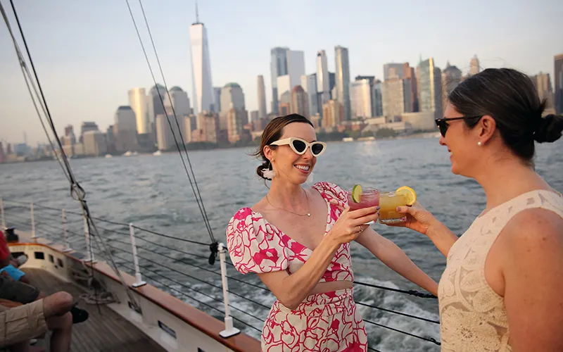 Tapas5 Two friends standing on the deck of the schooner america 2.0 clinking cocktails