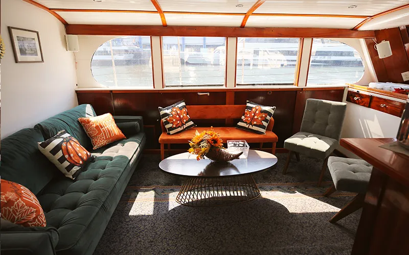 The interior lounge of yacht Full Moon with chairs, couch and table