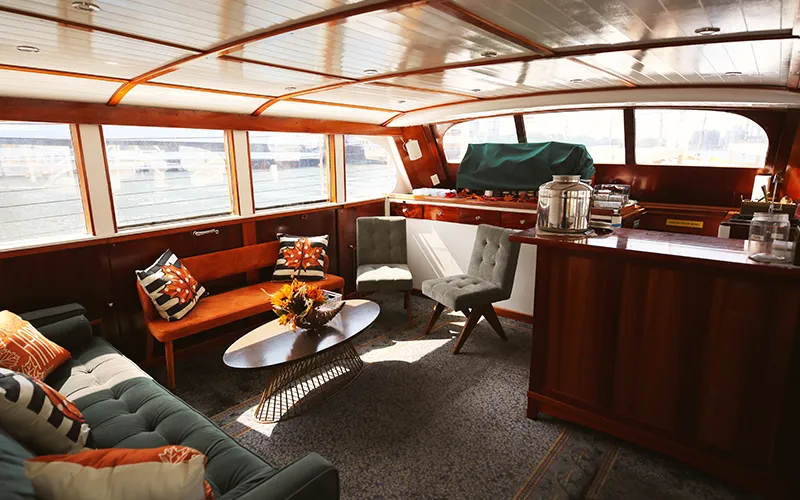 The interior lounge of yacht Full Moon with chairs, couch and table