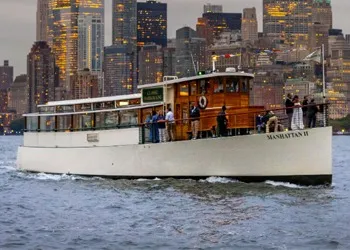 classic yacht in NY Harbor with the NYC Skyline in the background