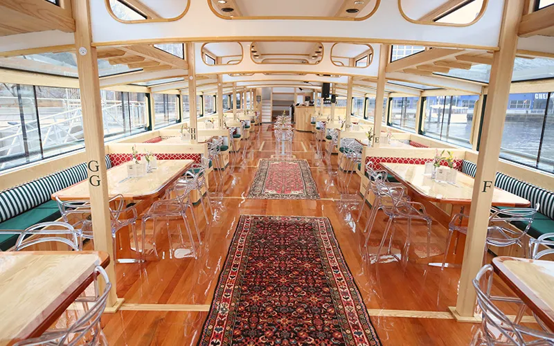 Grand Salon of the Yacht Manhattan III showcasing the windows, tables and chairs