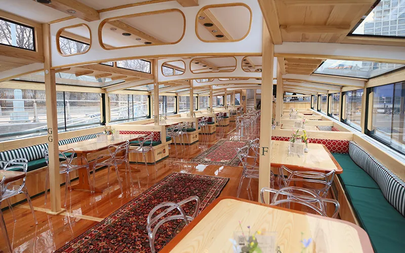 Grand Salon of the Yacht Manhattan III showcasing the windows, tables and chairs