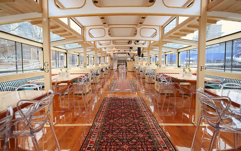 Grand Salon of the Yacht Manhattan III showcasing the windows, tables and chairs