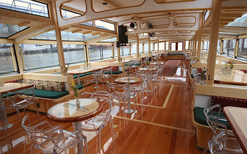 Grand Salon of the Yacht Manhattan III showcasing the windows, tables and chairs
