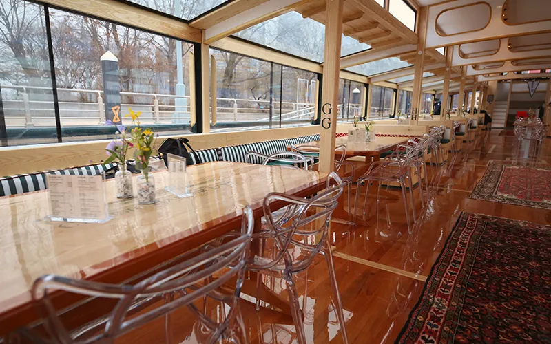 Grand Salon of the Yacht Manhattan III showcasing the windows, tables and chairs