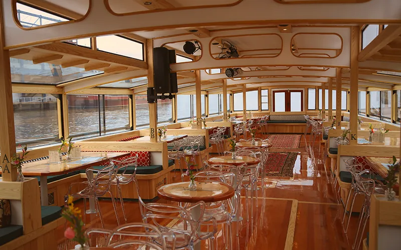 Grand Salon of the Yacht Manhattan III showcasing the windows, tables and chairs