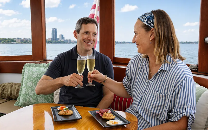 Couple enjoying champagne and hors d oeuvres on a boat in NY Harbor