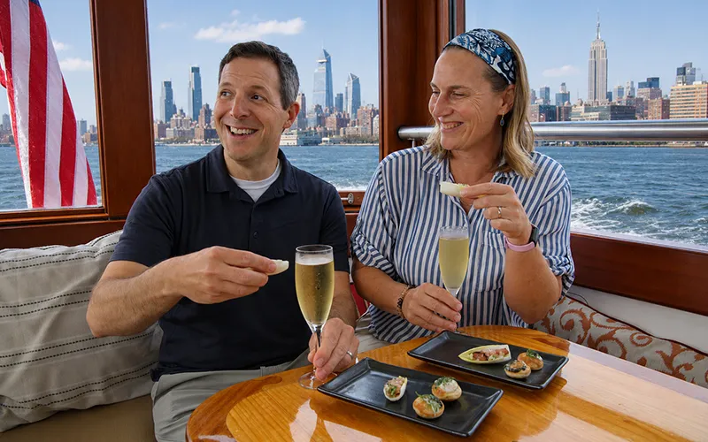 Couple enjoying champagne and hors d oeuvres on a boat in NY Harbor