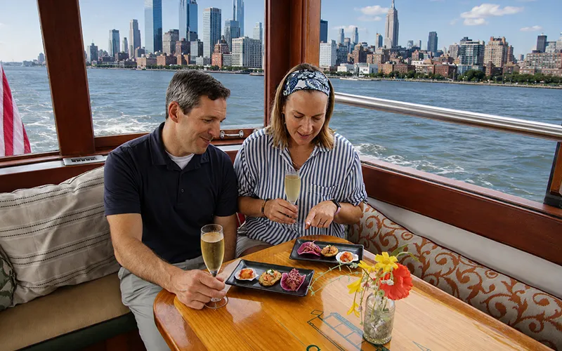 Couple enjoying champagne and hors d oeuvres on a boat in NY Harbor
