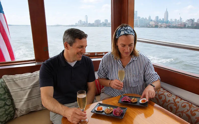 Couple enjoying champagne and hors d oeuvres on a boat in NY Harbor