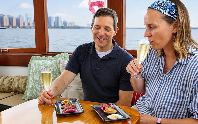 Couple enjoying champagne and hors d oeuvres on a boat in NY Harbor