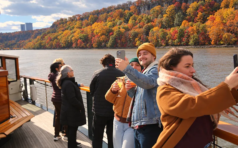 FallFoliage26 Couple taking a selfie on the bow of a boat with the Grand Palisade Fall Foliage in the background